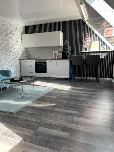 a kitchen with white cabinets and a table in a room at Cozy room with kitchen near the lake in Tõrva