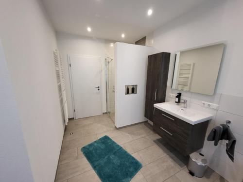 a white bathroom with a sink and a mirror at Ferienwohnung an der Eiswiese in Ebern