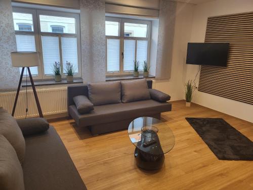 a living room with a couch and a glass table at Ferienwohnung an der Eiswiese in Ebern
