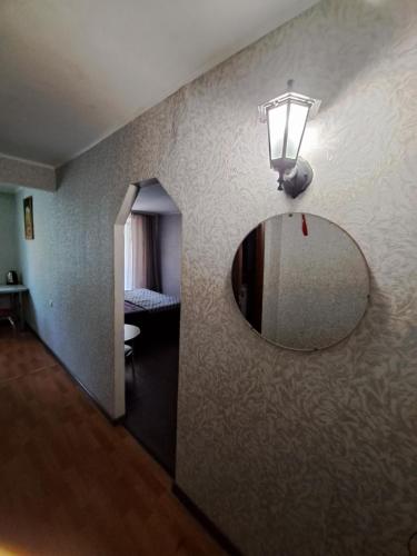 een kamer met een spiegel en een licht op een muur bij однокомнатная квартира в сердце города in Krivoy Rog