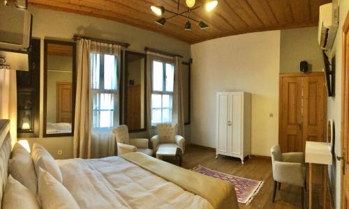 1 dormitorio grande con 1 cama grande y sillas en Grace Lounge Suite, en Antalya