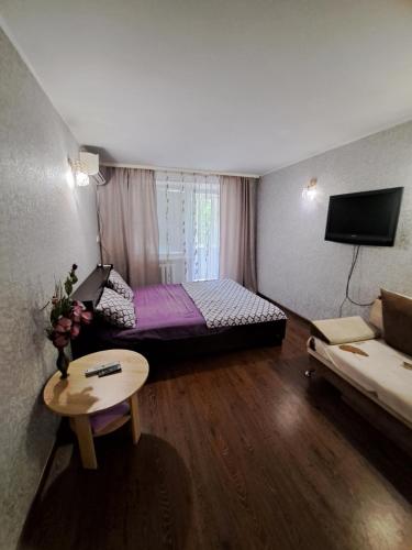 een kleine kamer met een bed en een bank bij однокомнатная квартира в сердце города in Krivoy Rog