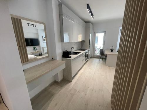a white bathroom with a sink and a mirror at L&C Platinum Property in Năvodari