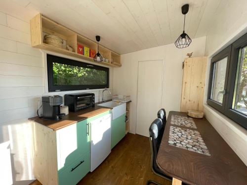 eine Küche mit einem Tisch in einem winzigen Haus in der Unterkunft Moho Nat’ure Tiny-house in Saint-Nabord