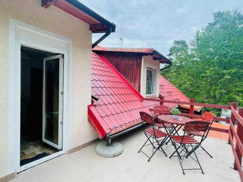 balcón con techo rojo, mesa y sillas en Róża Wiatrów, en Sztutowo