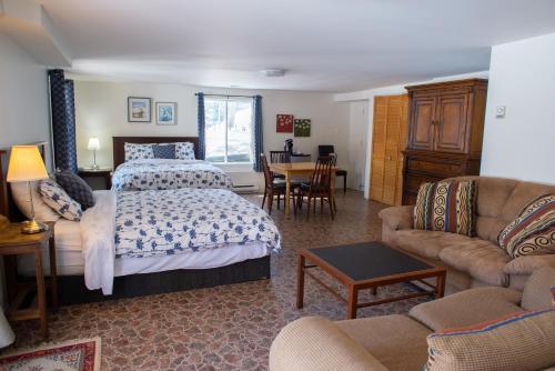 a bedroom with a bed and a living room at Auberge Spa & Beaux Reves in Sainte-Adèle