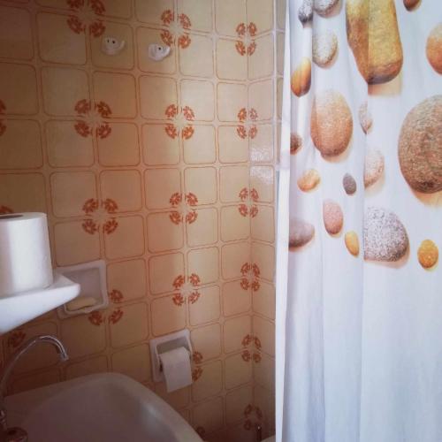 a bathroom with a shower curtain with donuts on the wall at Mini mountain view _ next to the sea in Possidi