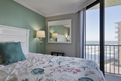 - une chambre avec un lit et une vue sur l'océan dans l'établissement 1 Bedroom -1 Bath Ocean View Condo At Ocean Trillium 503, à New Smyrna Beach