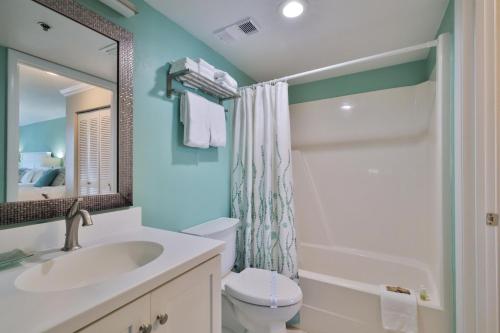 La salle de bains est pourvue d'un lavabo, de toilettes et d'un miroir. dans l'établissement 1 Bedroom -1 Bath Ocean View Condo At Ocean Trillium 503, à New Smyrna Beach