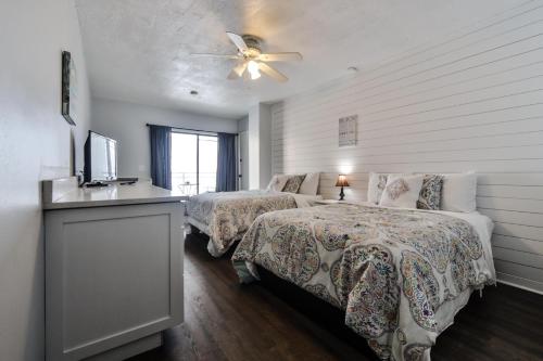 a bedroom with two beds and a ceiling fan at Coastal Life 206 - A 2Nd Floor Studio With 2 Single Beds in New Smyrna Beach