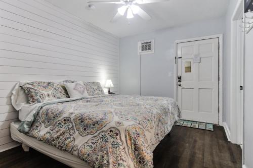 a white bedroom with a bed and a white door at Coastal Waters Life - 2nd Floor 1 Bedroom! in New Smyrna Beach