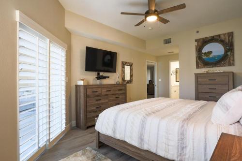 um quarto com uma cama e uma televisão de ecrã plano em Stunning 2 Bedroom 2 Bath Oceanwalk Condo em New Smyrna Beach