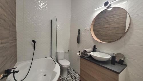 a bathroom with a sink and a toilet and a mirror at Glamour Apartman in Gyula