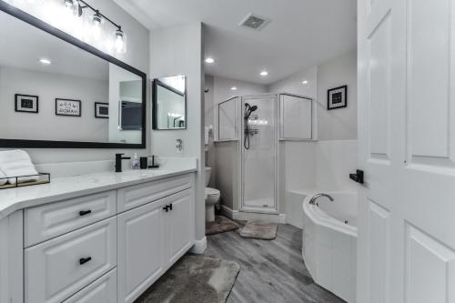 uma casa de banho branca com uma banheira, um WC e um lavatório. em Stunning 2 Bedroom 2 Bath Oceanwalk Condo em New Smyrna Beach