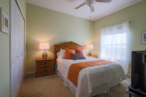 a bedroom with a bed and a fan and a window at 3 Bedroom 2 Bath Oceanwalk Condo With Estuary Views in New Smyrna Beach