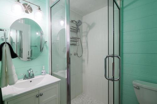 a bathroom with a shower and a sink and a mirror at Pineapple Pad Studio At Coastal Waters 105 in New Smyrna Beach