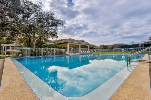 a swimming pool with blue water in front of a house at Sea Woods Large 1 Bedroom Condo And A Whole Lot Of Amenities! in New Smyrna Beach