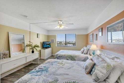 a bedroom with two beds and a tv in it at The Sea Esta At Coastal Waters in New Smyrna Beach