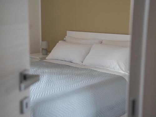 - un lit avec des draps et des oreillers blancs dans l'établissement Central Station Home - Fanale Rentals, à Palerme