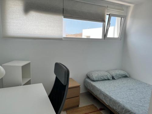 een kleine slaapkamer met een bed en een raam bij Casa el Timple in Costa Teguise