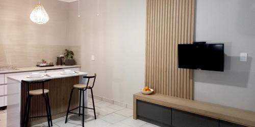 cocina con barra y TV en la pared en Lemon Tree Manor - Scandi Suite, en Groblersdal