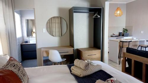 a bedroom with a bed and a small kitchen at Lemon Tree Manor - Scandi Suite in Groblersdal