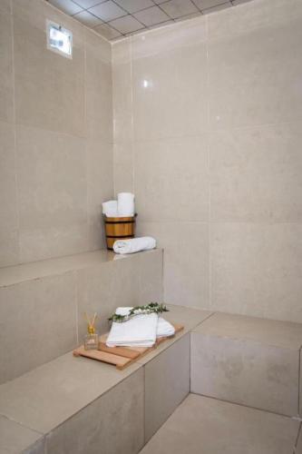 a white bathroom with towels on a shelf at Taiwan Hotel in Ribeirão Preto