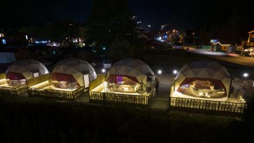 un grupo de cuatro tiendas de campaña en un patio por la noche en Besega Bungalow, en Uzungöl