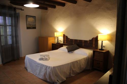 a bedroom with a bed with two lamps on it at Apartaments Rurals Ai Manyac in San Miguel de Cruilles