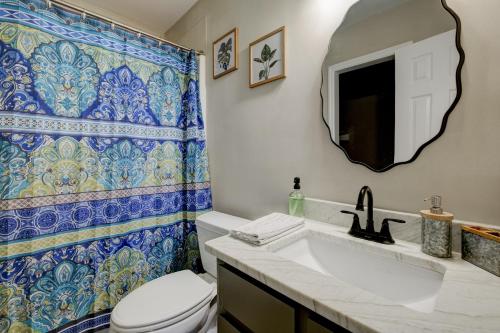 y baño con aseo, lavabo y espejo. en Enchanting 2-bedroom By The Lake, en Newnan