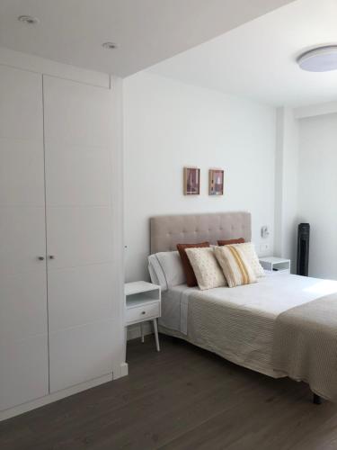 a white bedroom with a bed and a white cabinet at Habitación con baño privado Bilbao in Bilbao