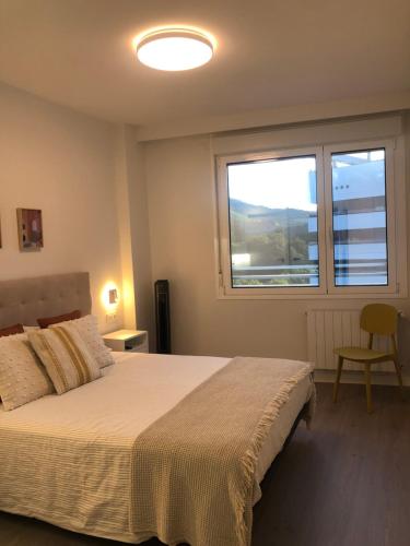 a bedroom with a bed and a large window at Habitación con baño privado Bilbao in Bilbao