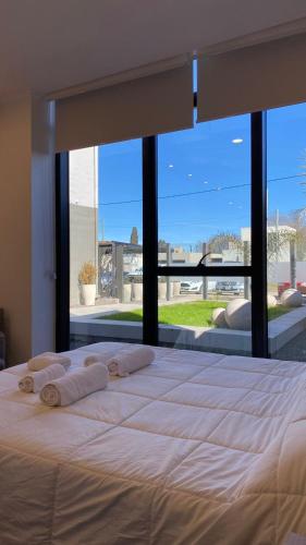 Una cama grande en un dormitorio con una ventana grande. en Apart IMEB spa & wellness, en Río Cuarto