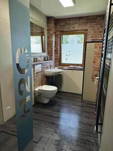 a bathroom with a toilet and a sink and a window at URLAUB mit HUND -Ferienwohnung "AhriBella"- in Glowe