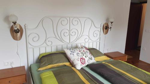 a bed with a white headboard and two pillows at Pr' Šovarjo in Zgornje Gorje