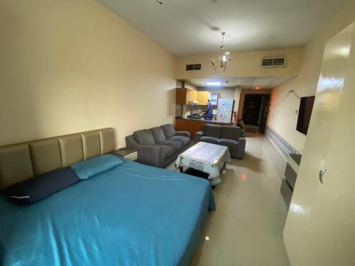 1 dormitorio con 1 cama azul y sala de estar en استديو مفروش بتاور سي عجمان شامل جميع الفواتير للايجار الشهري, en Ajman