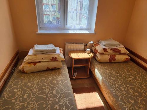 two beds in a small room with a window at Mieszkanie u Diany i Piotra in Ustka