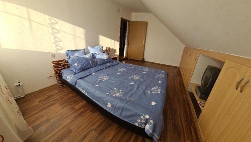 1 dormitorio con 1 cama con edredón azul en Casa Valea Lupului 