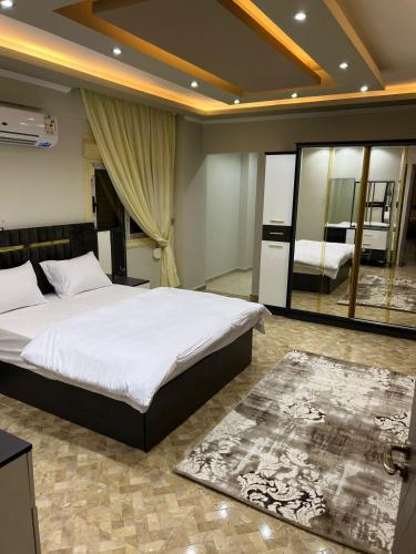 1 dormitorio con 1 cama grande y espejo en شقه فندقيه للايجار اليومي التجمع الخامس01068880306, en El Cairo