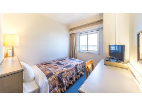 een hotelkamer met een bed en een televisie bij Sunrise Inn - Vacation STAY 75396v in Kaizuka