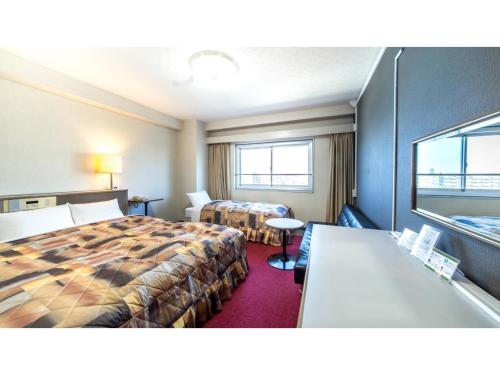 貝塚市にあるSunrise Inn - Vacation STAY 75402vのベッド2台とテーブルがあるホテルの部屋