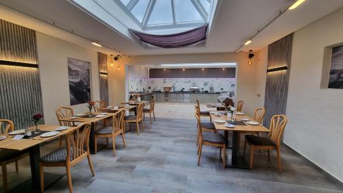 um restaurante com mesas e cadeiras de madeira e uma clarabóia em Hotel Zum Anker em Neumagen-Dhron