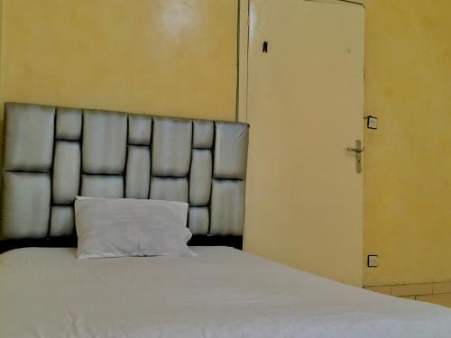 un letto con un cuscino bianco accanto a una porta di BEA & DOZO a Casablanca