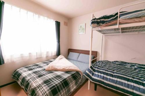 a bedroom with two bunk beds and a window at Dream Misono - Vacation STAY 14778 in Sapporo