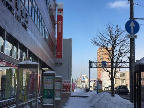 a snow covered street in a city with buildings at Dream Misono - Vacation STAY 14778 in Sapporo