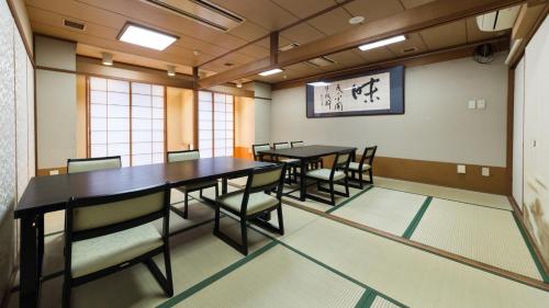 a conference room with two tables and chairs and a clock at Sunrise Inn - Vacation STAY 75380v in Kaizuka