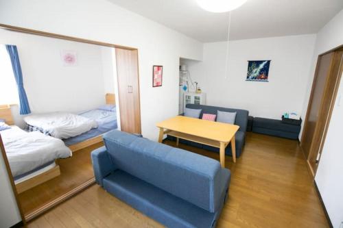 um quarto com um sofá azul, uma cama e uma mesa em Dream Misono - Vacation STAY 14776 em Sapporo