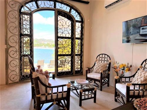 una sala de estar con una ventana abovedada y sillas en Villa Amor en Sayulita