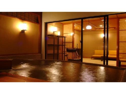 a room with a large glass door and a couch at Yumura Onsen Tomiya - Vacation STAY 81718v in Shinonsen
