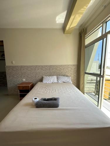 a large bed in a room with a large window at Hospedaje Aloha - Tumbes in Tumbes